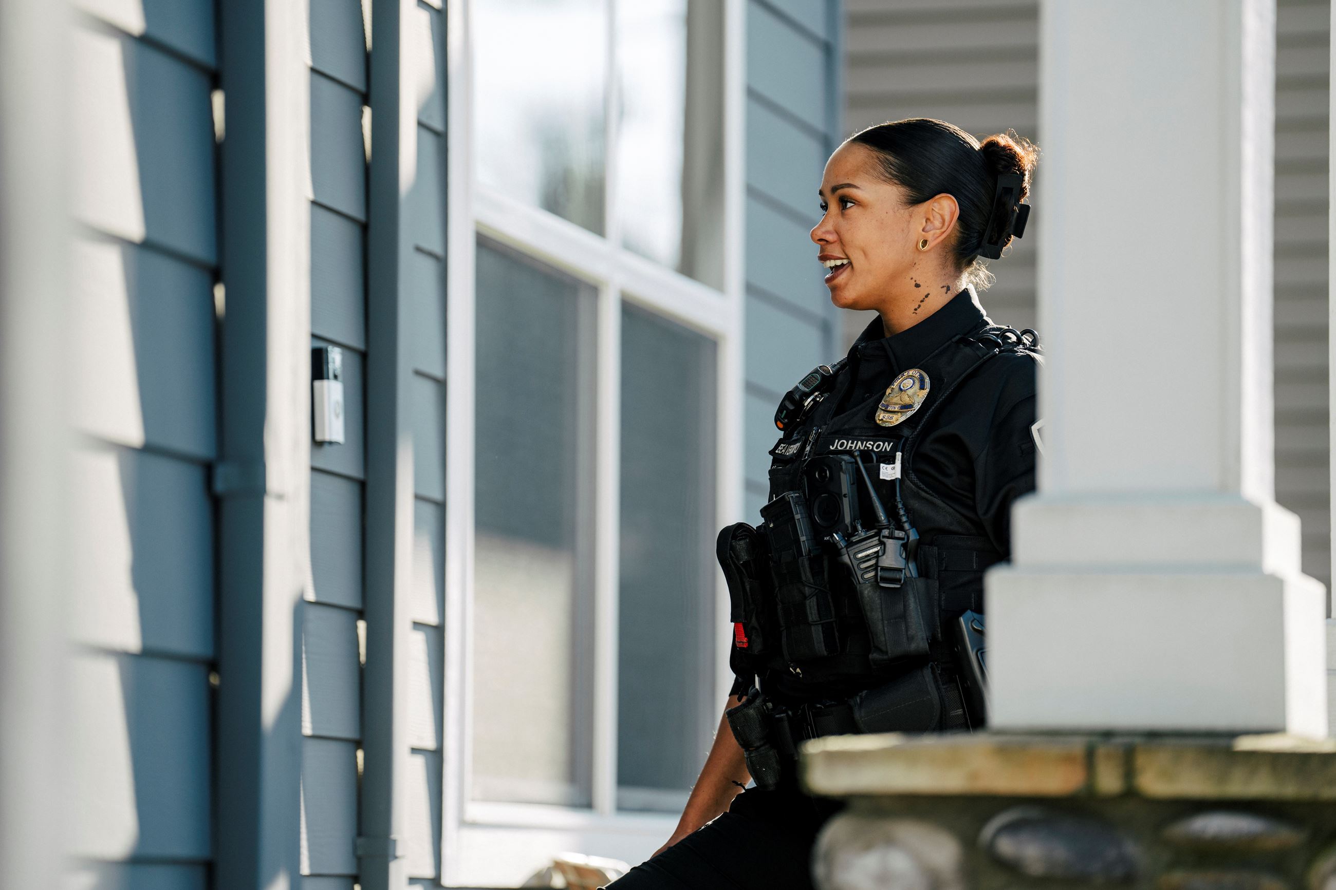 smiling police officer approaches a residential front door