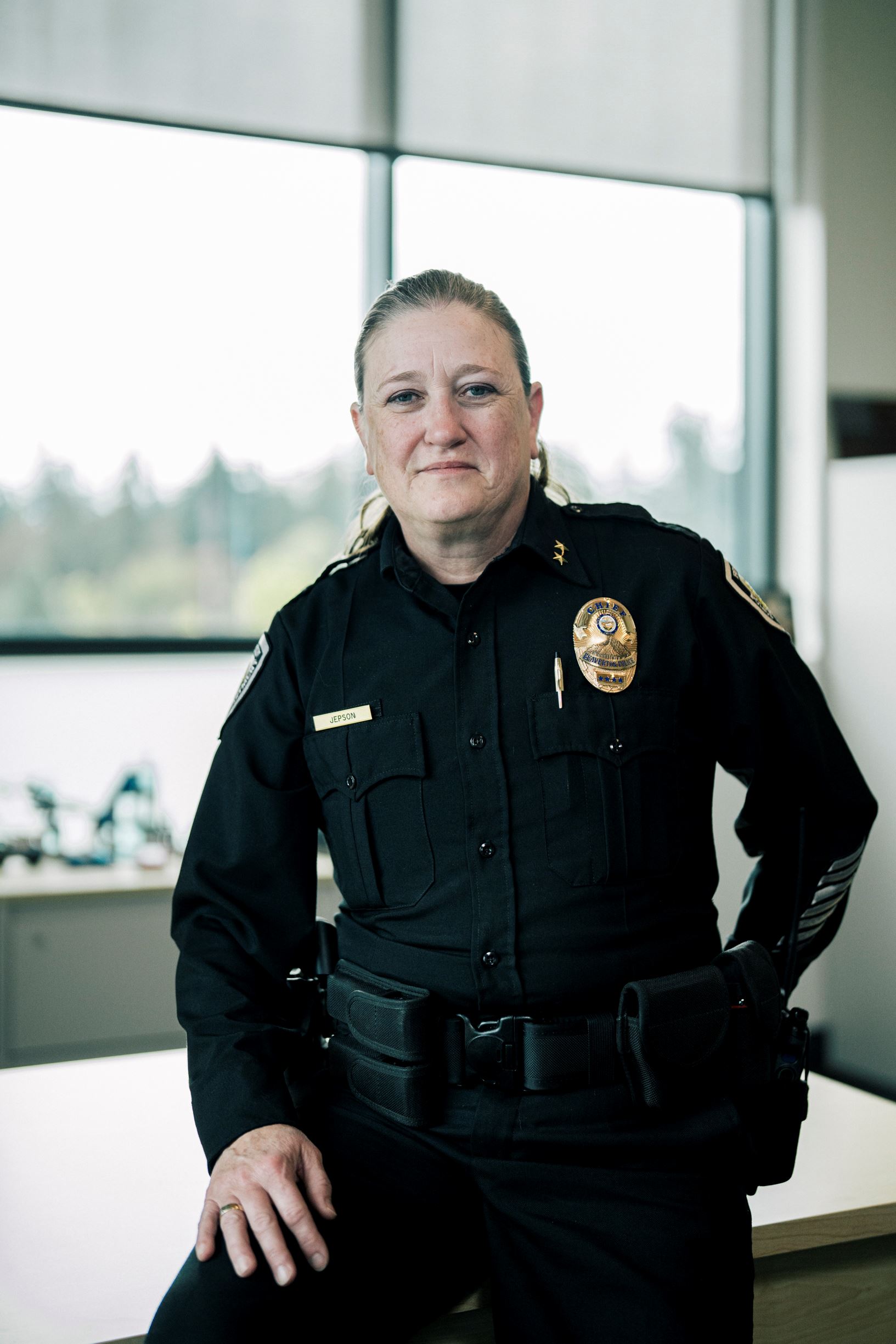 Chief Stacy Jepson wearing her uniform and an American flag is behind her.